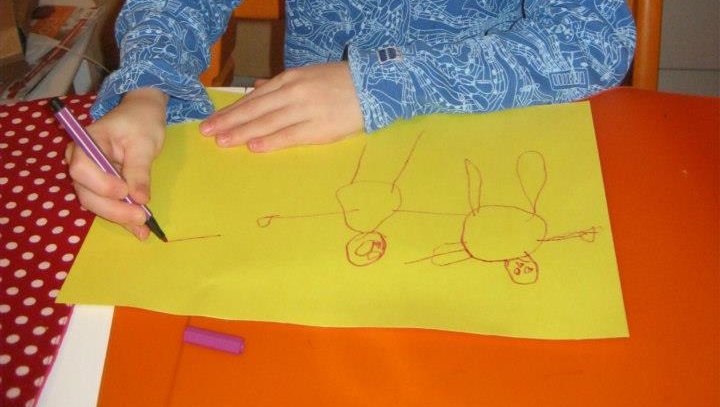 lapsi on piirtänyt tussilla paperille ihmishahmoja